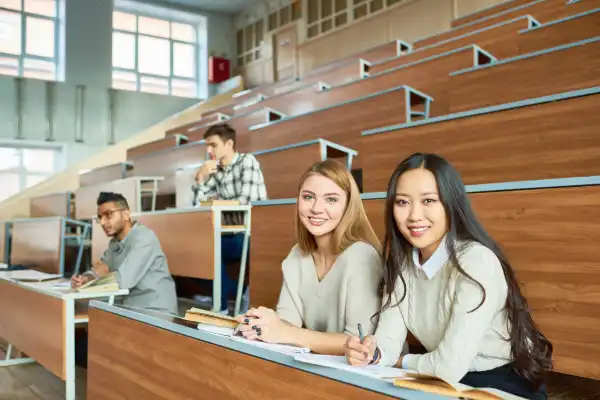 Post-secondary students seated in a lecture hall, engaged in collaborative learning.