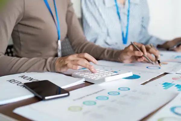 Business professionals analyzing financial reports with a calculator, representing QuickBooks accounting skills.