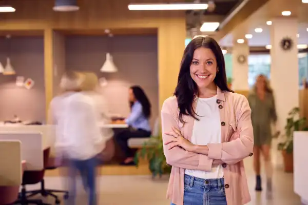 Confident professional standing in a modern workplace, representing Microsoft productivity and workplace technology skills.