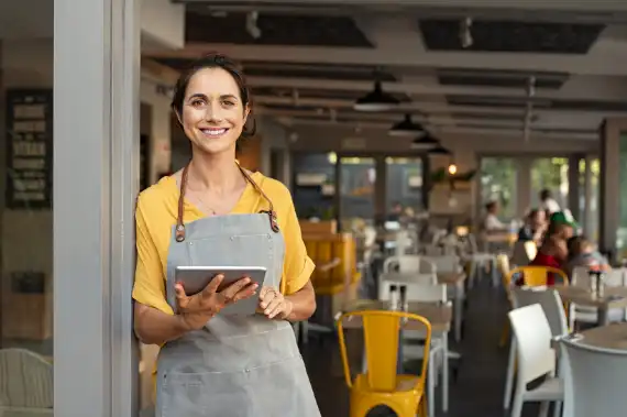 Small business professional using a tablet to manage operations and customer service with AI-powered tools.